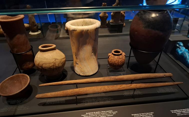 Imagen principal - Los posibles bastones de mando junto a otras piezas predinásticas en la exposición y otras vistas de la muestra, que reúne una selección de más de 400 piezas