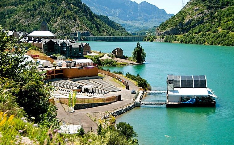 Imagen principal - Arriba, el escenario sobre el lago de Lanuza (Huesca) de Pirineos Sur; abajo a la izquierda el escenario de Noches del Botánico (Madrid); y a su derecha una actuación en la isla de San Simón (Vigo) en el Festival Sinsal 