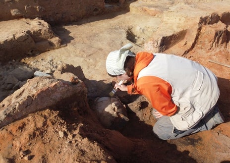 Imagen secundaria 1 - Miembros del equipo de 'Construyendo Tarteso' desentierran una jarra de bronce, una vasija cerámica y uno de los fragmentos de la columna