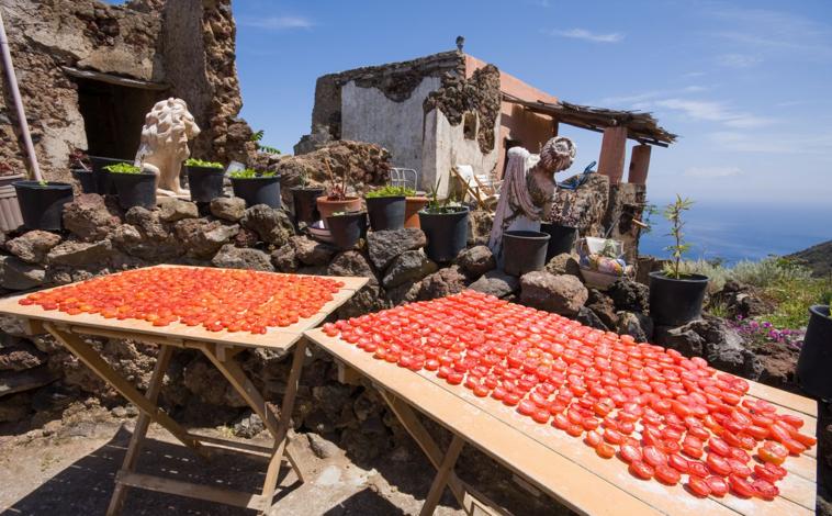 Imagen principal - De arriba abajo: tomates puestos a secar en Filicudi, panorama de Lípari y un viñedo en Pantelaria