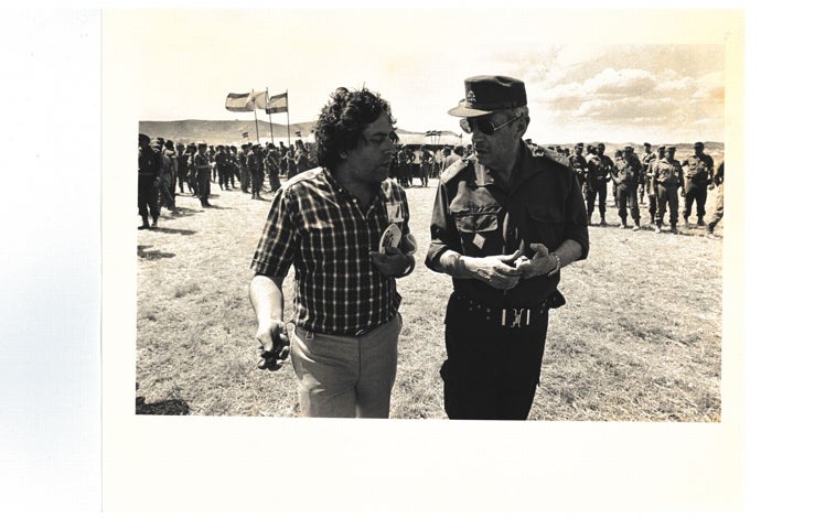 Imagen principal - Miguel Ángel Aguilar (arriba) hablando con un alto mando en un campamento del Ejército español, en 1975. Abajo a la izquierda, llegando al Juzgado Militar, donde iba a prestar declaración por el presunto delito de injurias al Ejército, en 1980. a la derecha, un detalle de la portada del libro 'No había costumbre. Crónica de la muerte de Franco' (Ladera Norte).