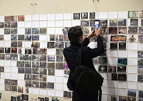 Imagen secundaria 1 - En las imágenes, de arriba abajo, detalle del montaje de 'Wonderland'; un hombre toma una foto con su móvil de las fotos 'de cabecera' de la creadora; retrato de Annie Leibovitz en la Fundación MOP