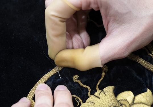 Detalle de una de las técnicas recosiendo el manto.