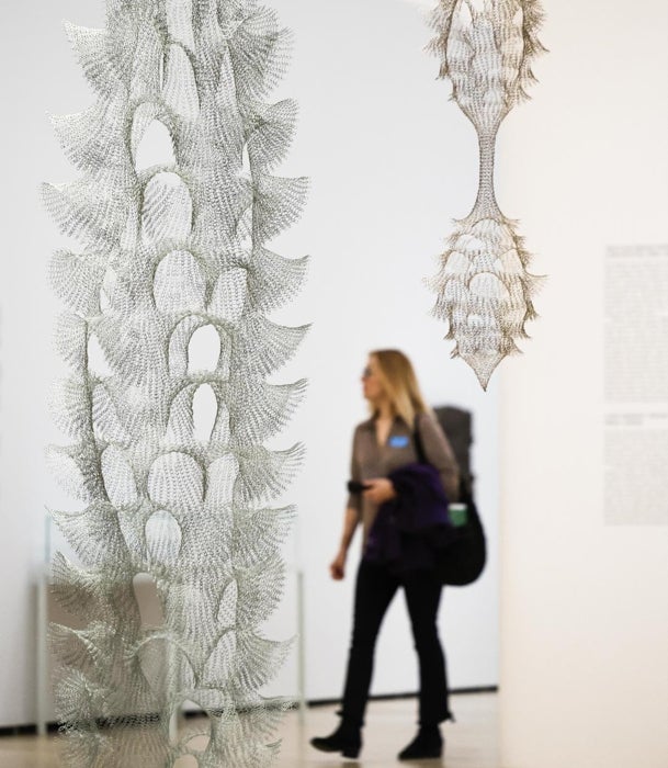 Una joven pasea junto a las esculturas de alambre de Ruth Asawa en el Guggenheim Bilbao.
