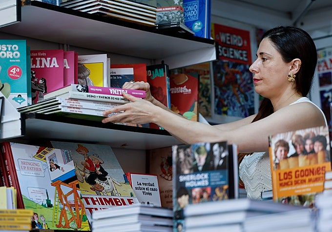 Una librera ordenando los libros de su caseta en la Feria del libro de Madrid