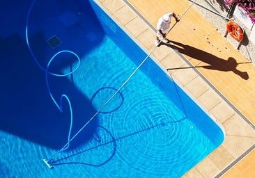 Un socorrista limpiando una piscina comunitaria