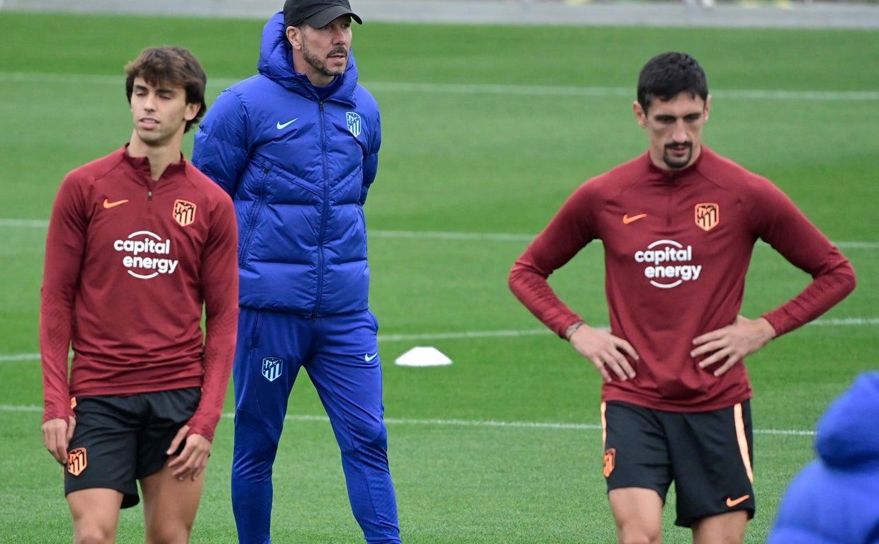 Joao y Savic, ante Simeone en el entrenamiento de este lunes en Madrid