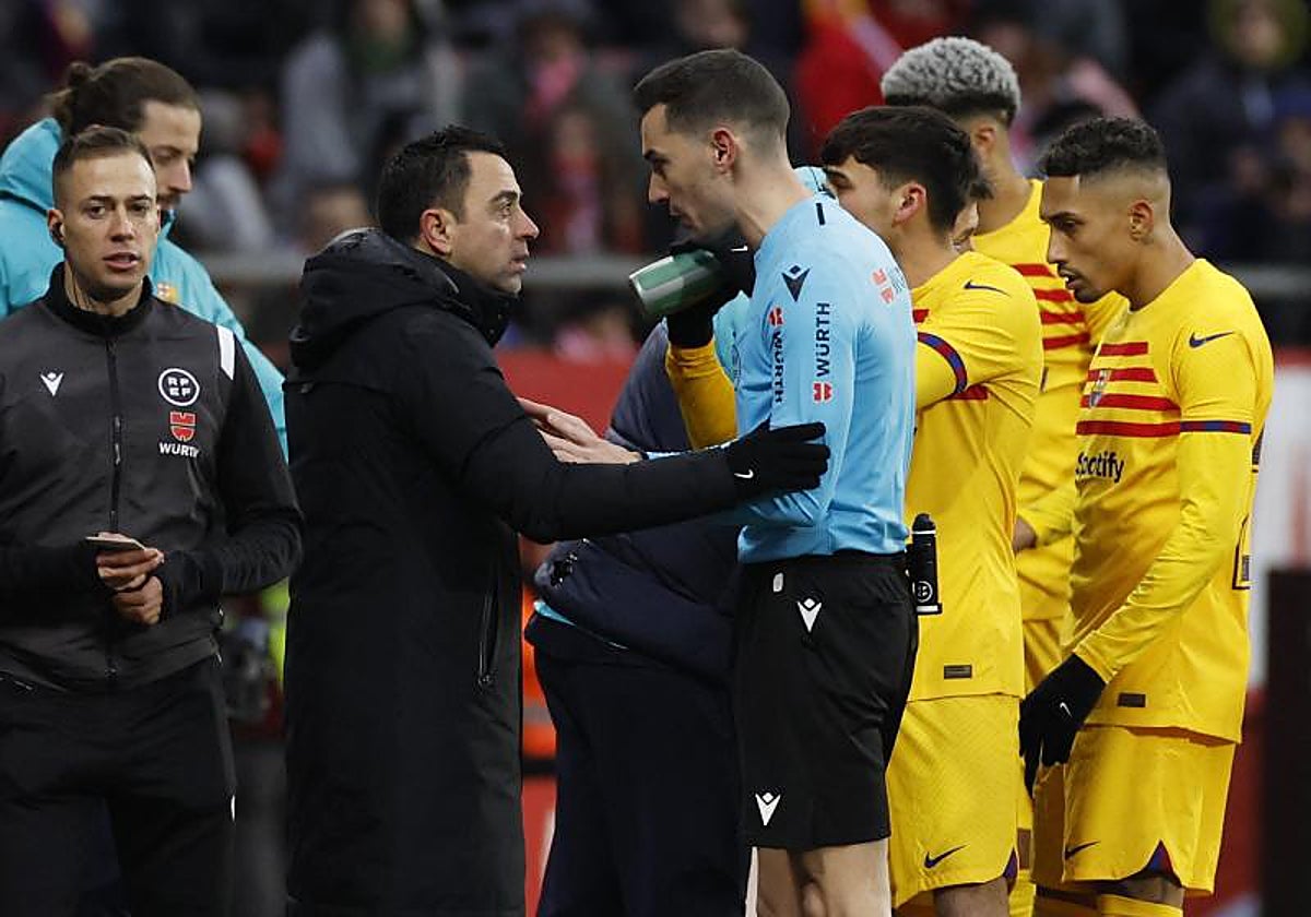 Xavi dialoga con el Muñiz Ruiz, árbitro del partido