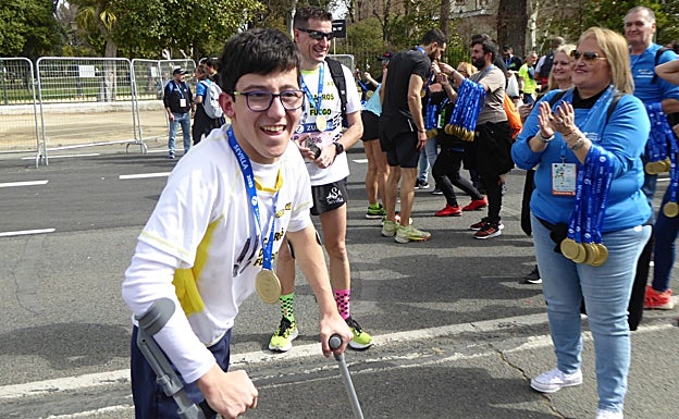 Nacho con la medalla que le dan a los corredores al terminar la carrera