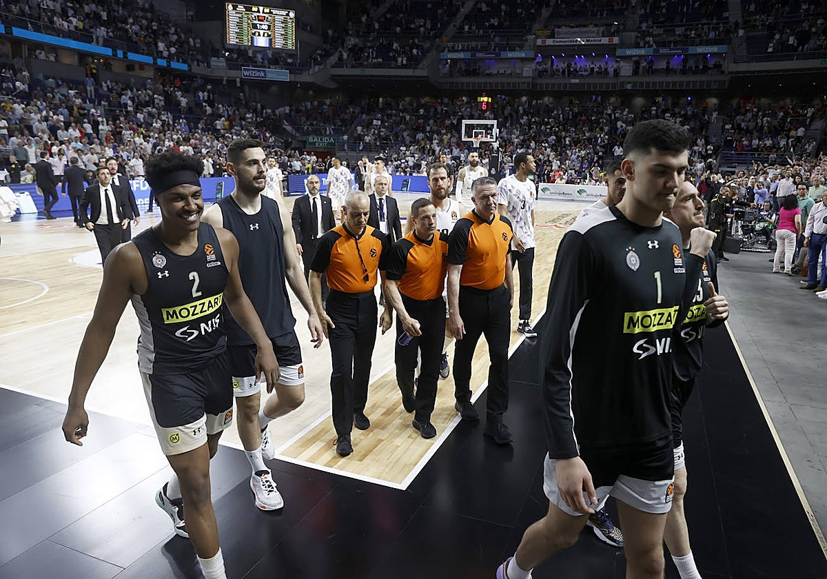 Los árbitros del partido se retiran tras dar por finalizado el choque