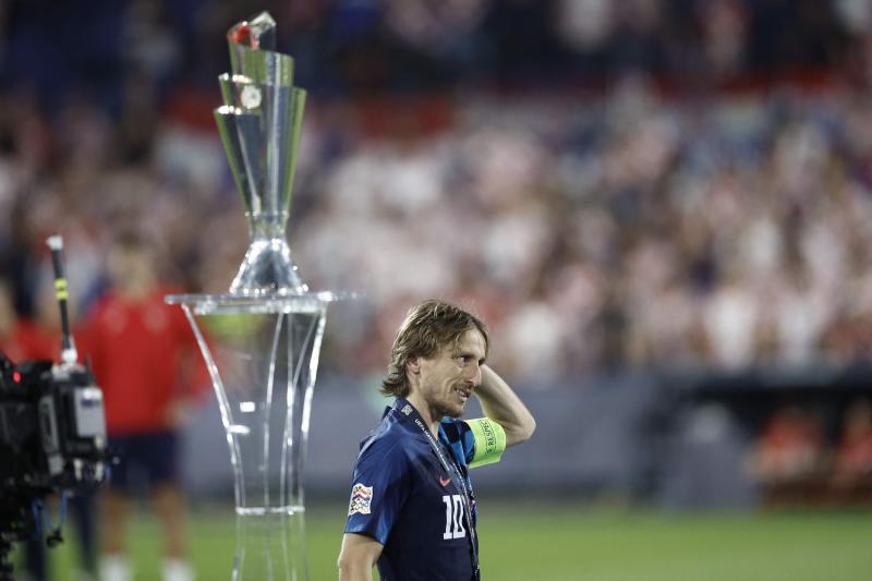 Luka Modric pasa junto al trofeo que acabó en manos de España