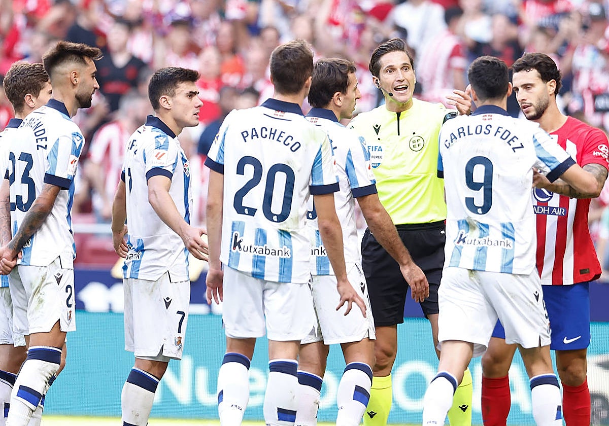 Los jugadores de la Real protestan el penalti al árbitro