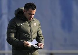 Xavi consulta unas notas durante el entrenamiento de este sábado