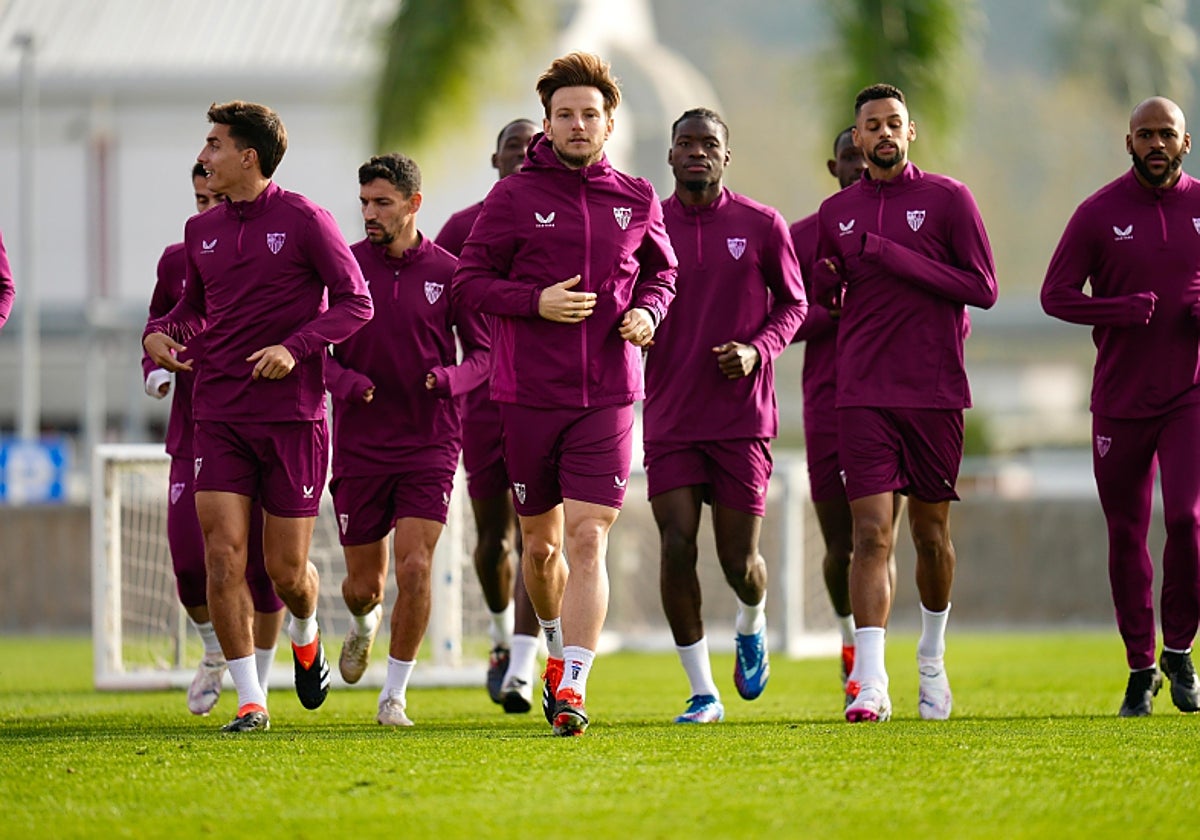 Los jugadores del Sevilla realizan carrera continua sobre el césped del Ramón Sánchez-Pizjuán