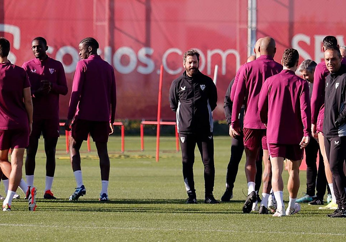 Futbolistas del Sevilla y el entrenador, Quique Sánchez Flores, en el inicio del entrenamiento de este sábado