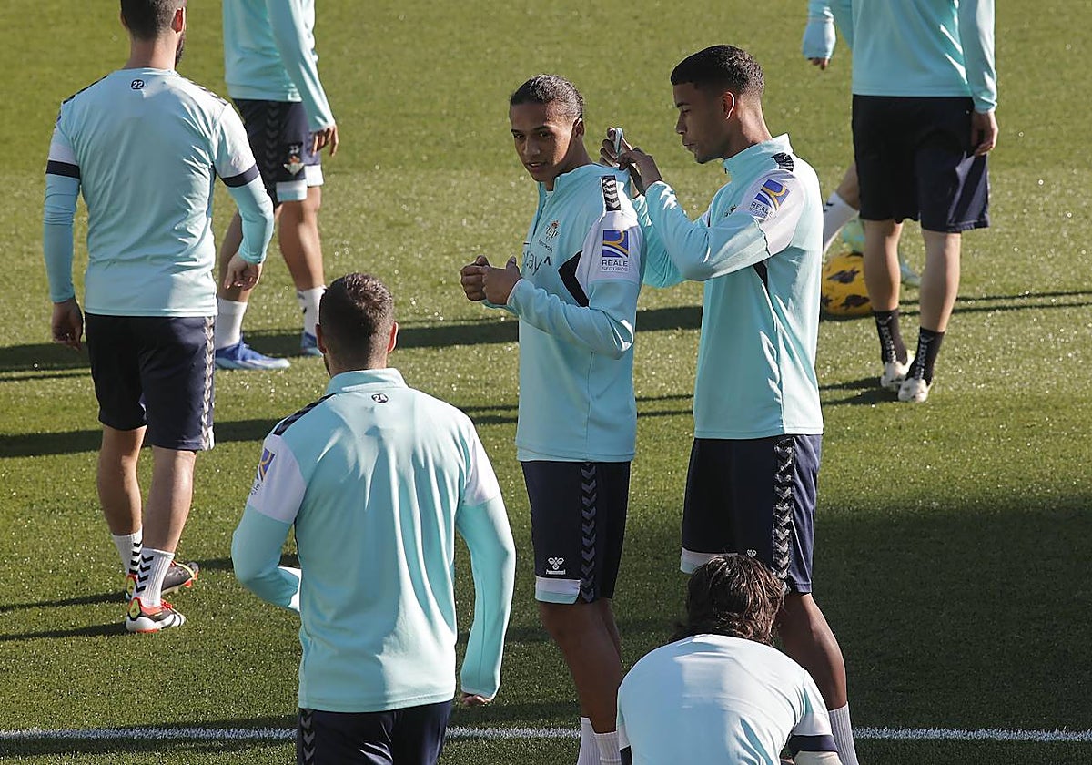 Álex Pérez le coloca a Yanis el medidor antes del entrenamiento del Betis en el estadio Benito Villamarín