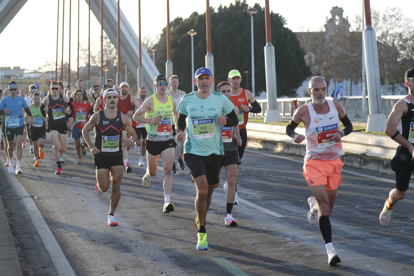 Corredores del maratón a su paso por el puente de la Barqueta