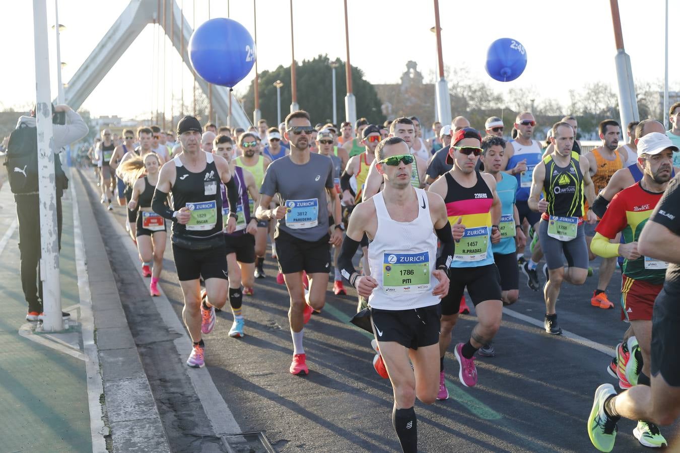 Corredores del maratón a su paso por el puente de la Barqueta
