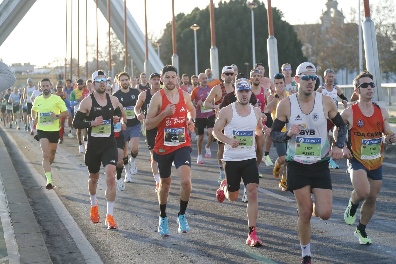 Corredores del maratón a su paso por el puente de la Barqueta