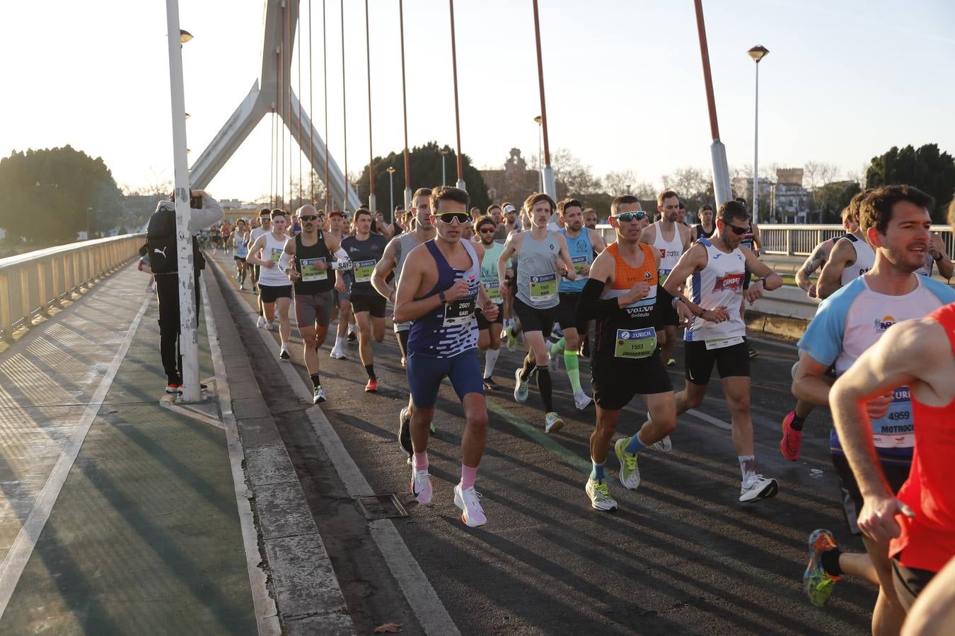 Corredores del maratón a su paso por el puente de la Barqueta