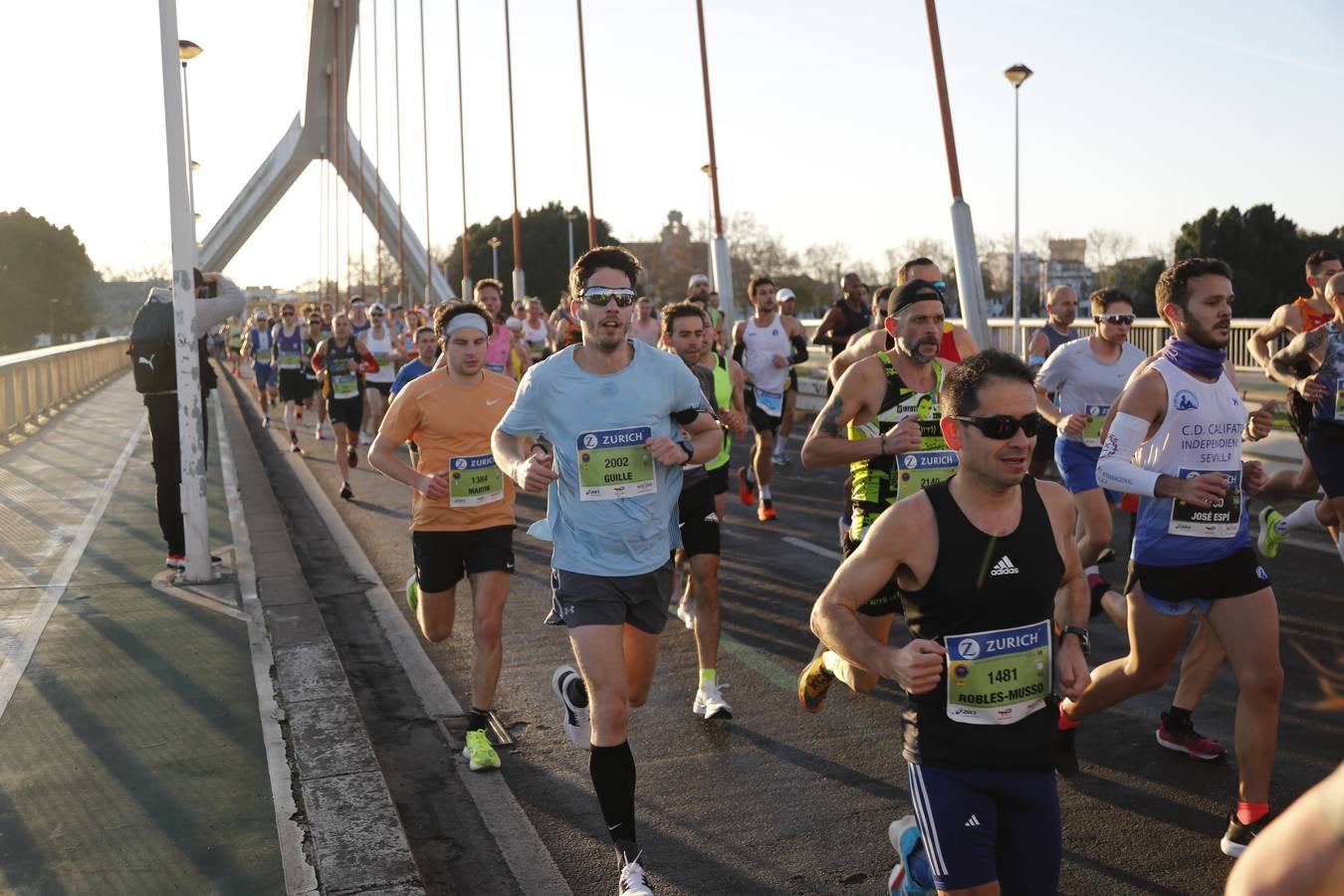 Corredores del maratón a su paso por el puente de la Barqueta