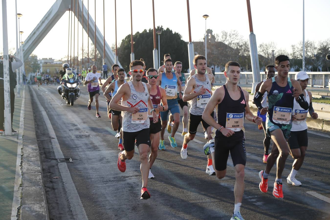 Corredores del maratón a su paso por el puente de la Barqueta