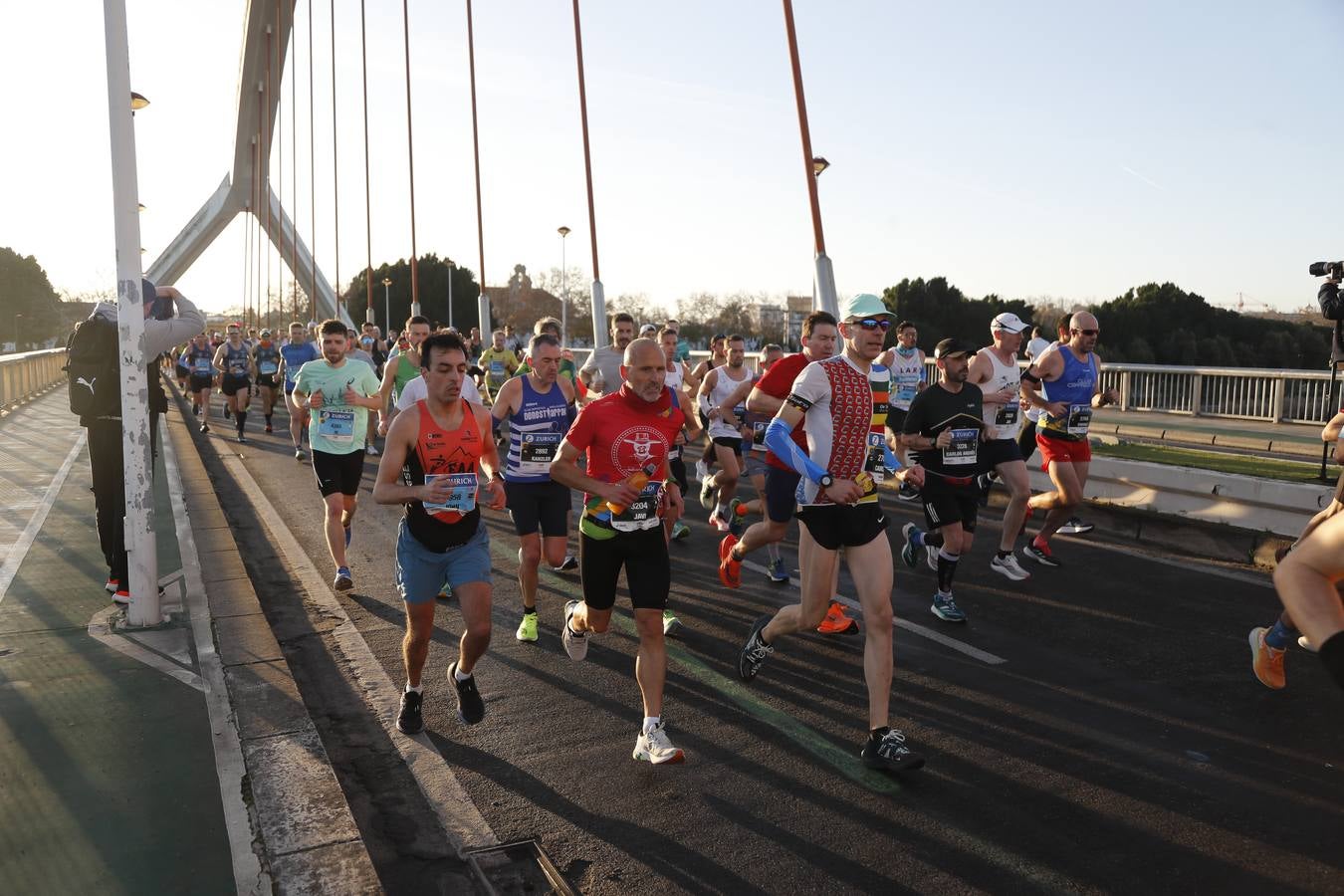 Corredores del maratón a su paso por el puente de la Barqueta