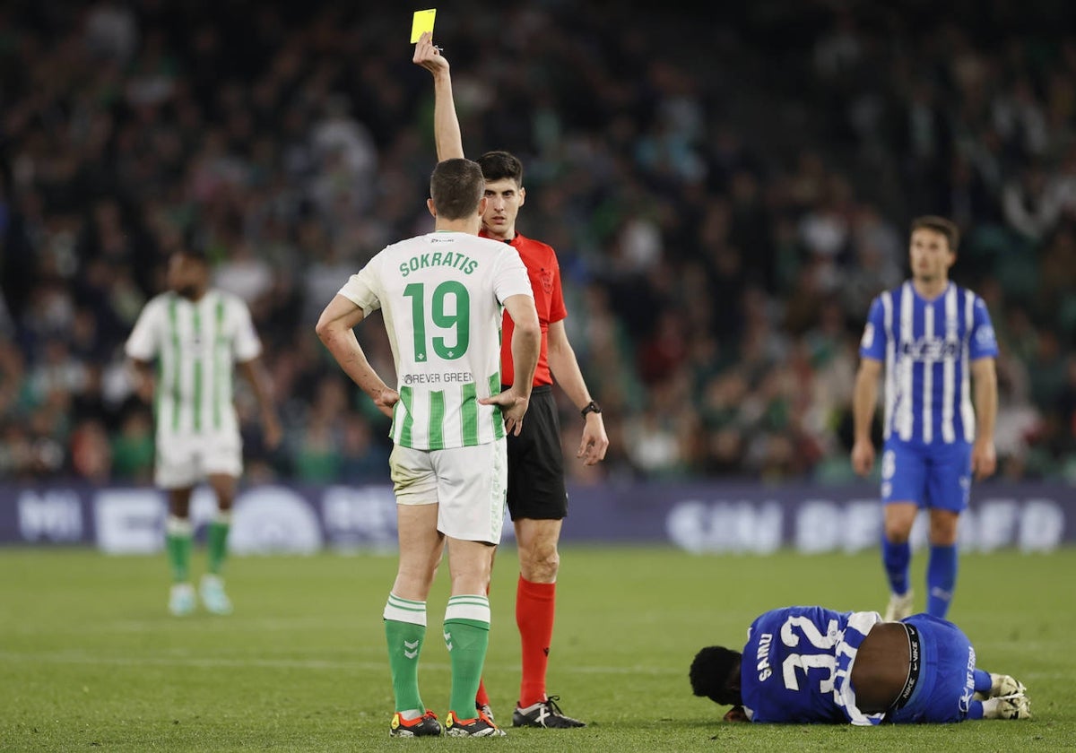 Busquets Ferrer le muestra la amarilla a Sokratis tras pitar falta de éste sobre Samu en el Betis - Alavés