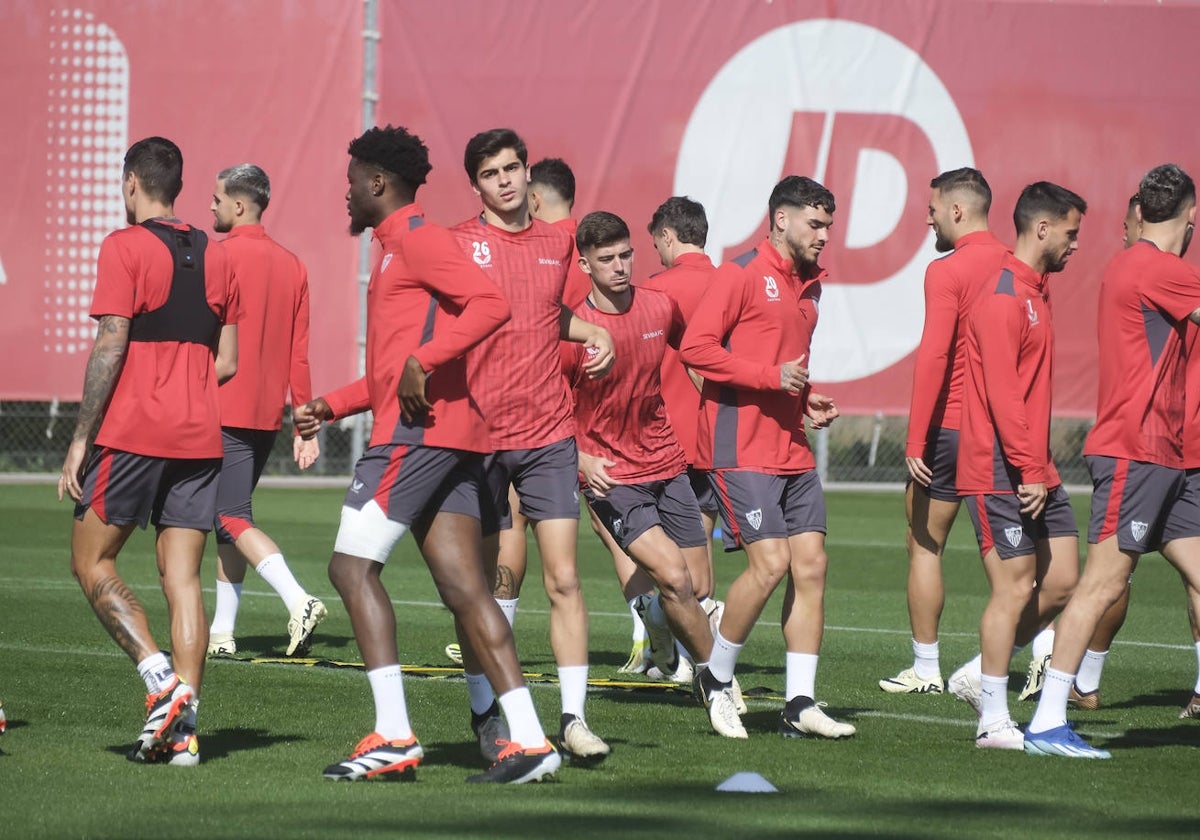 Varios futbolistas del Sevilla, en el inicio del entrenamiento de este sábado