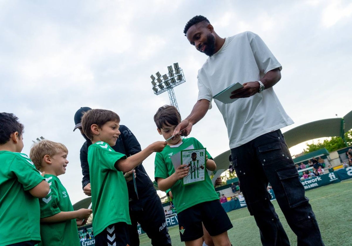 Bakambu reparte fotos suyas autografiadas a niños en su visita a la Escuela Betis