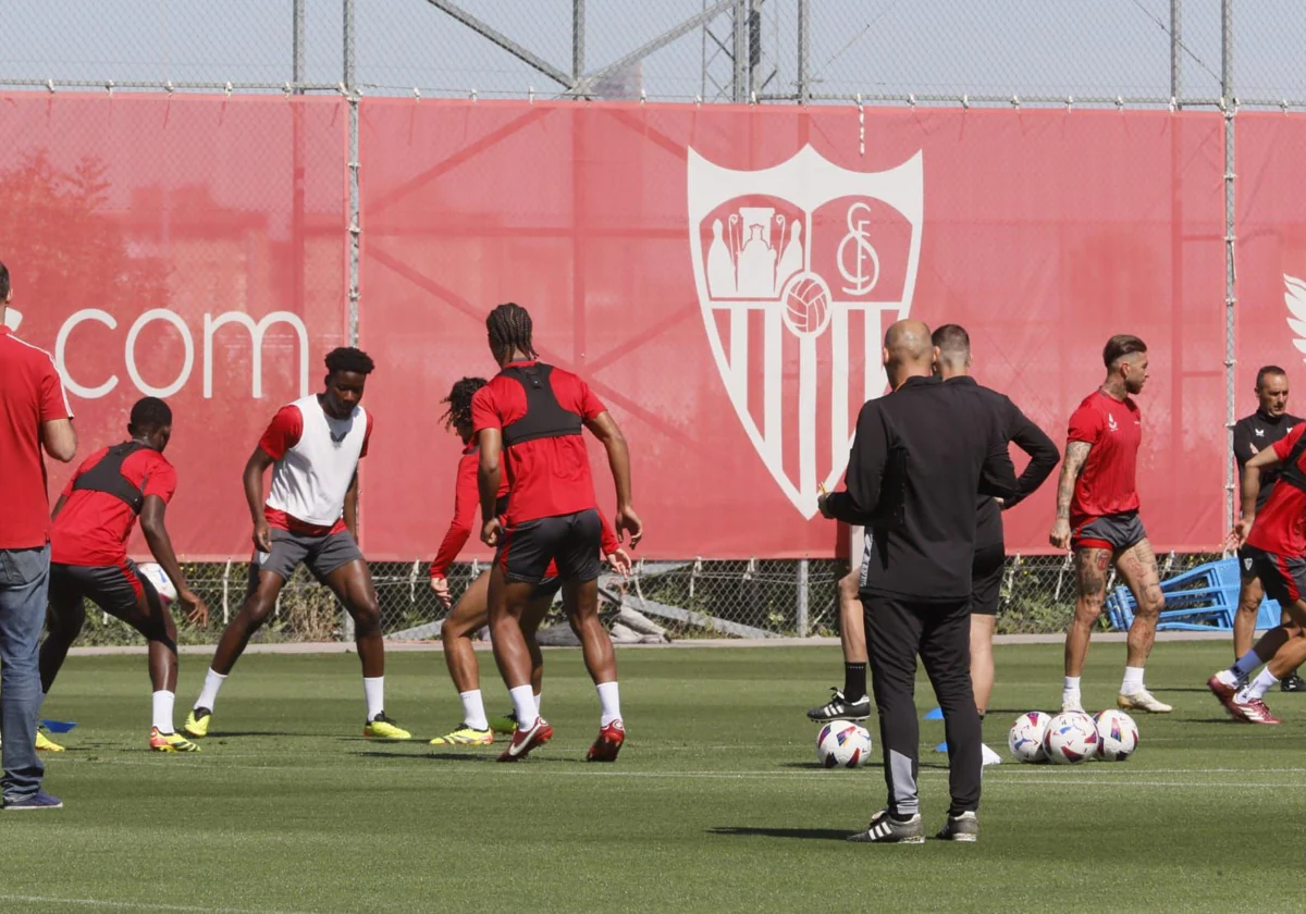 Varios futbolistas del Sevilla, en el inicio del entrenamiento de este sábado