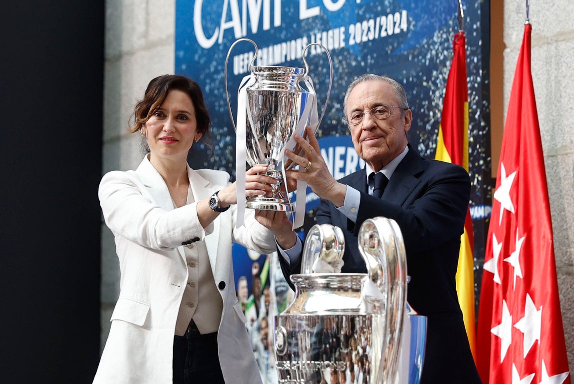 El presidente del Real Madrid, Florentino Pérez, entrega a Ayuso una réplica de la copa de Europa