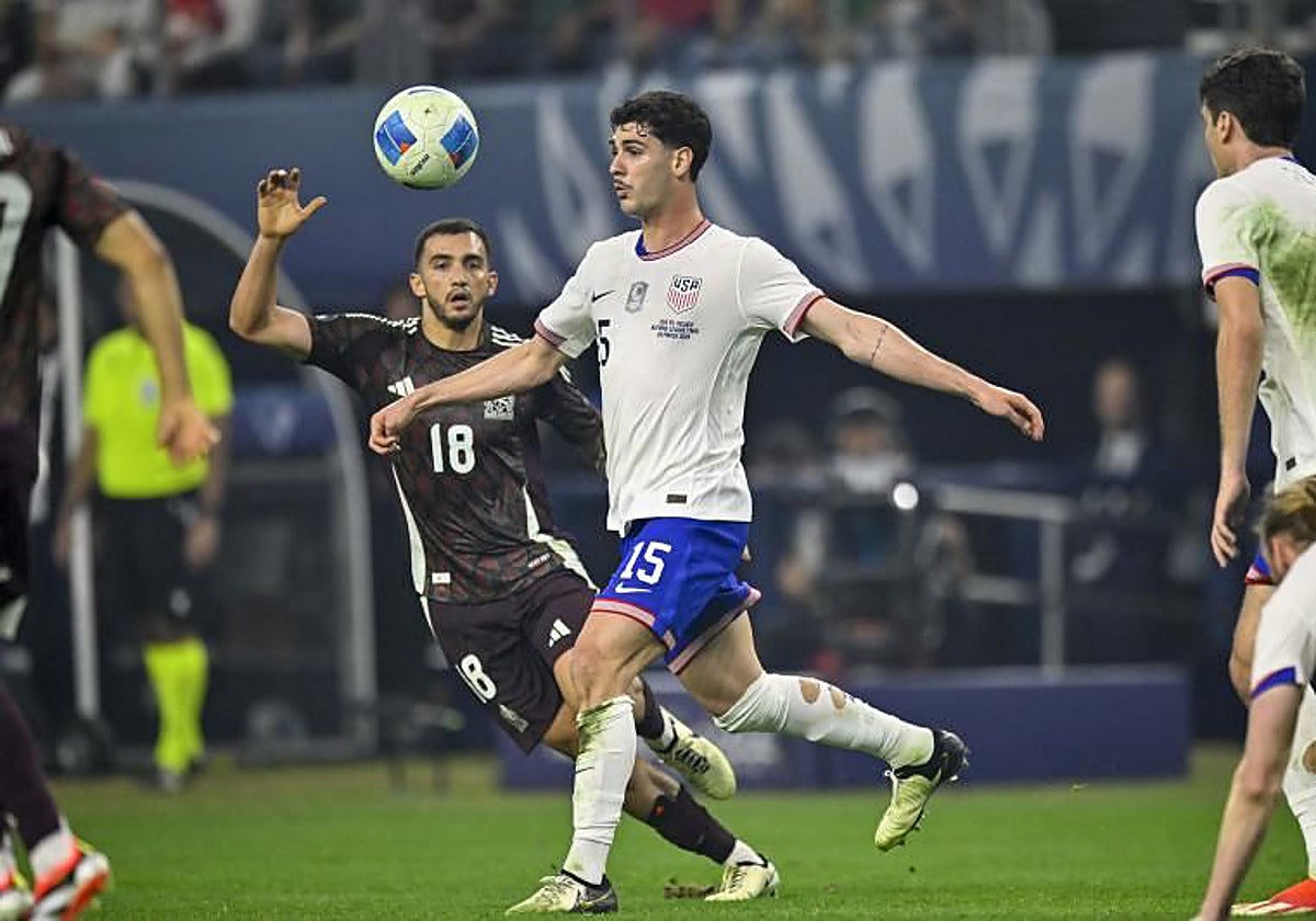 Johnny Cardoso controlando un balón frente a un jugador de la Selección de México