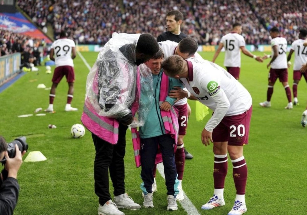 Un recogepelotas es ayudado por los jugadores del West Ham