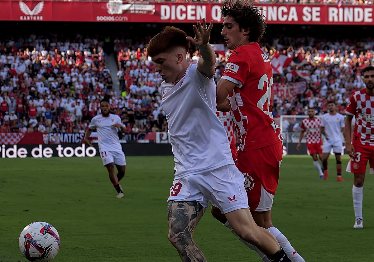 Valentín Barco pelea con Bryan Gil un balón en el Sevilla-Girona