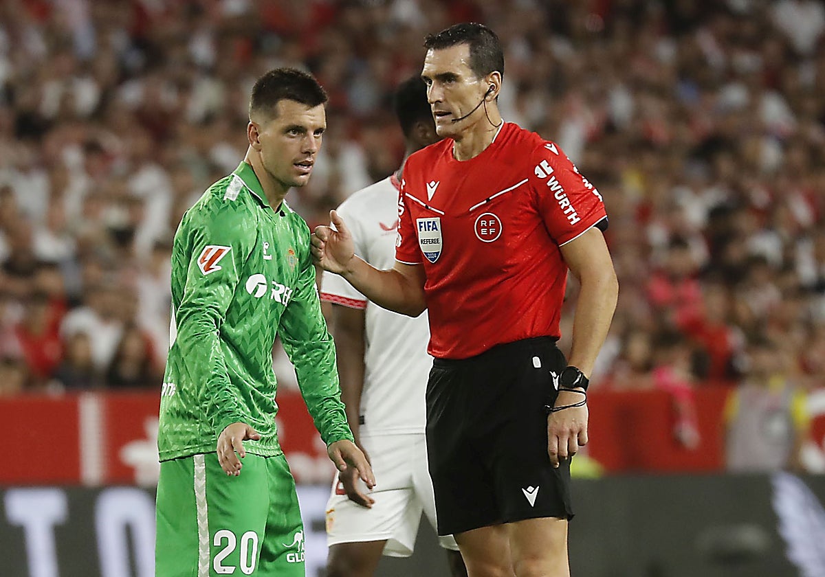 Lo Celso y Martínez Munuera, durante el Sevilla-Betis de este domingo