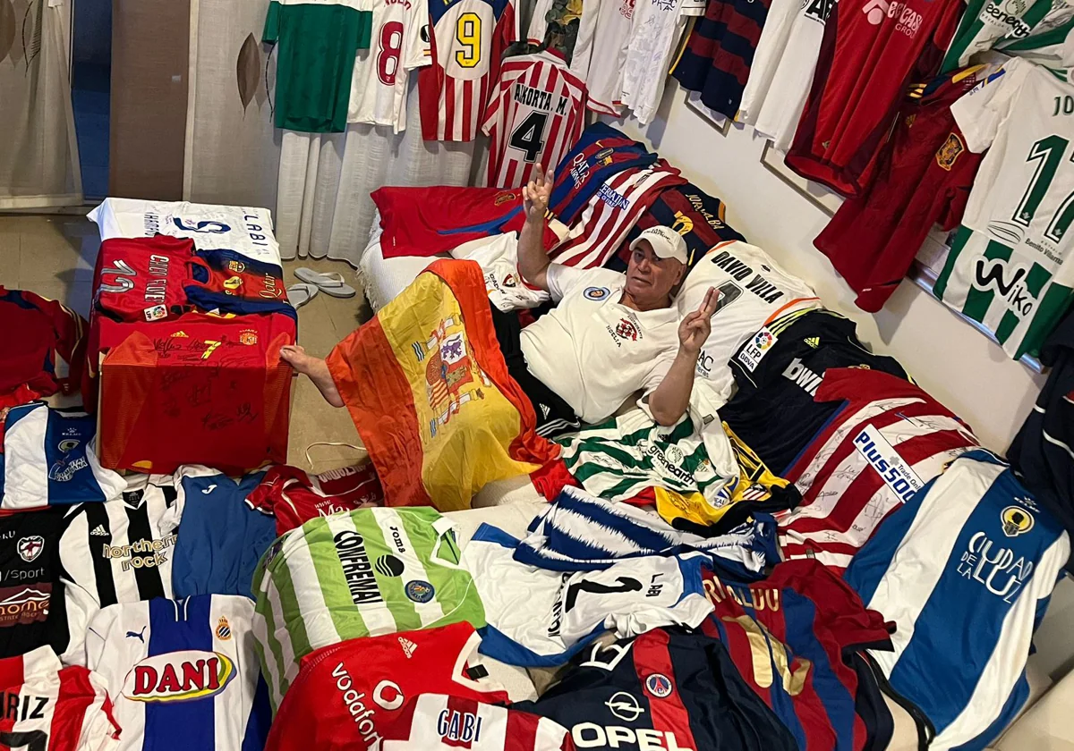 Juan Mesa posa junto a su colección de camisetas regaladas por futbolistas