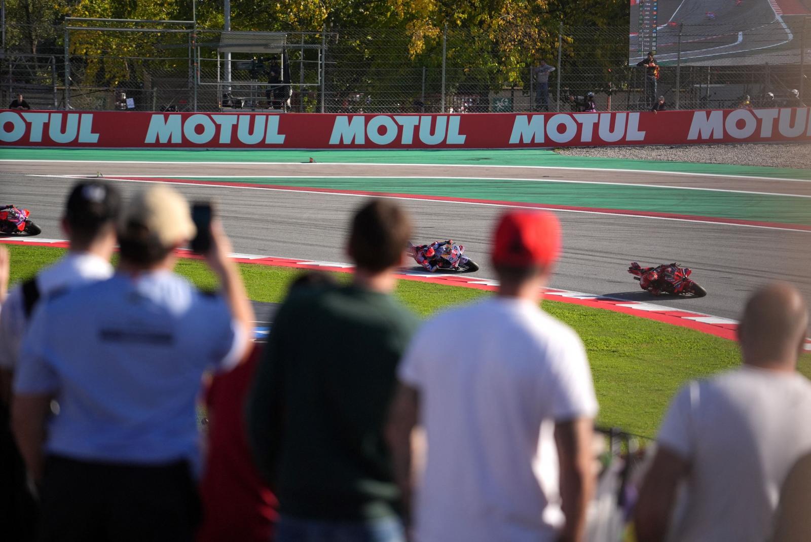 Los espectadores observan al piloto italiano de Ducati Francesco Bagnaia, seguido por el piloto español de Ducati Marc Márquez y el piloto español de Ducati Jorge Martín.