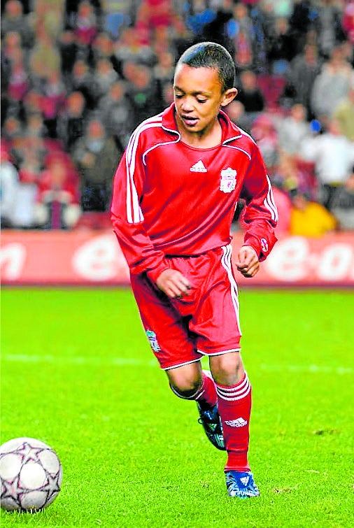 Imagen secundaria 2 - Arriba, Alexander-Arnold junto a Gerrard, mítico capitán 'red'. Abajo, su mural de Sylbil Road: «Un chico normal de Liverpool que cumplió sus sueños» y durante su estancia en la cantera del Liverpool