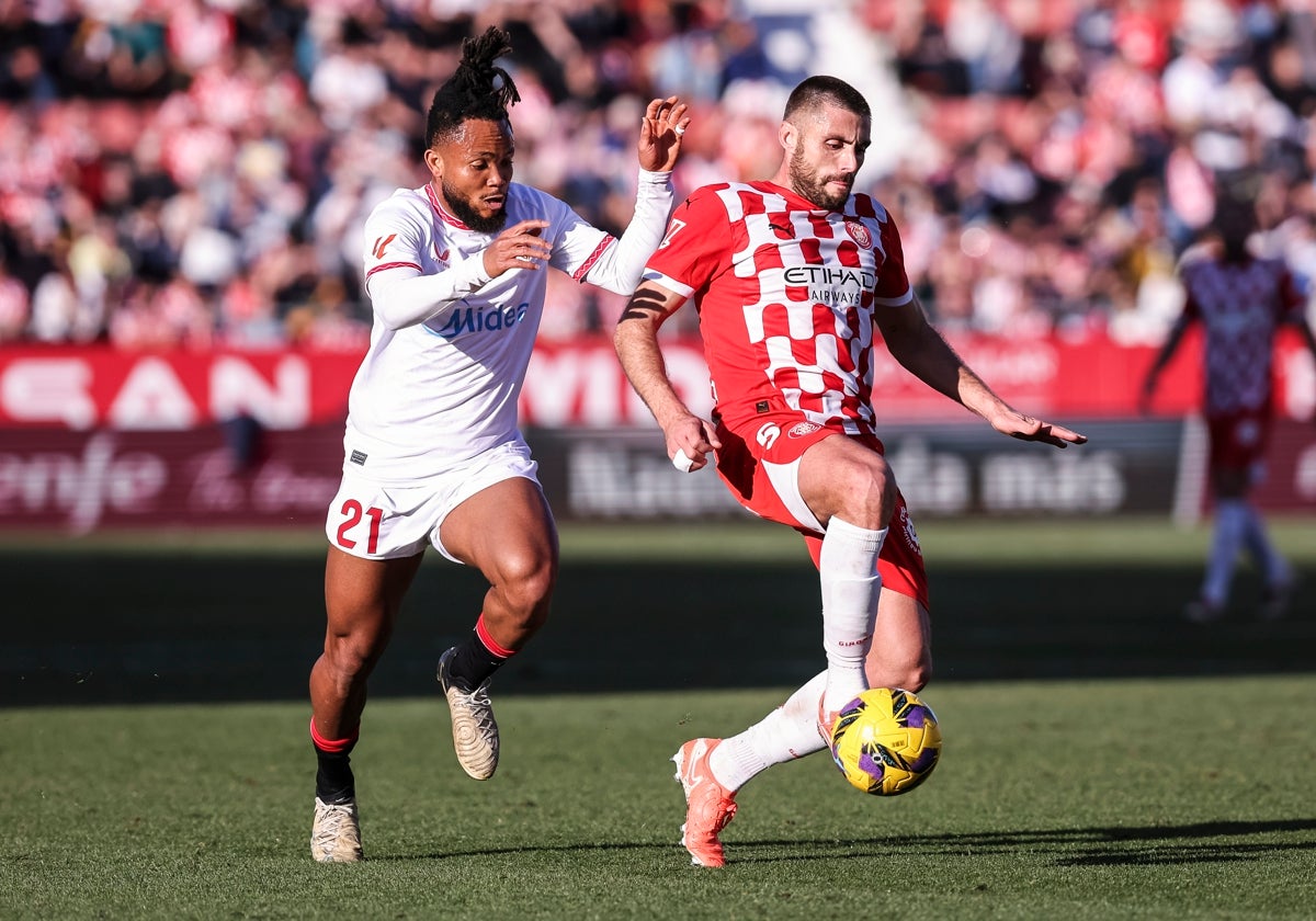 Chidera Ejuke disputa un balón con David López en el Girona - Sevilla