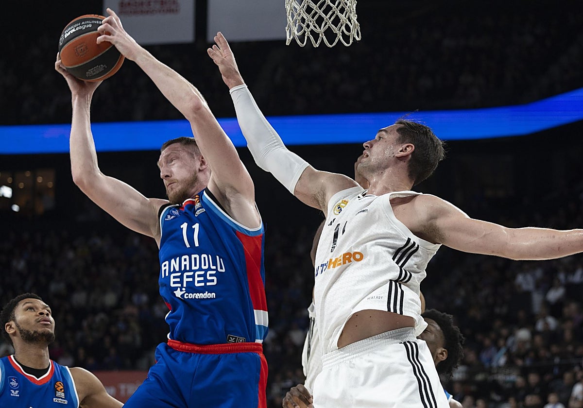 Hezonja intenta robarle el balón al letón Smits