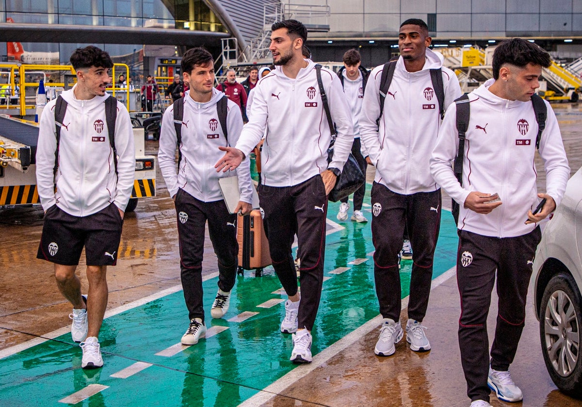 Rafa Mir y unos compañeros del Valencia en el aeropuerto de la capital valenciana