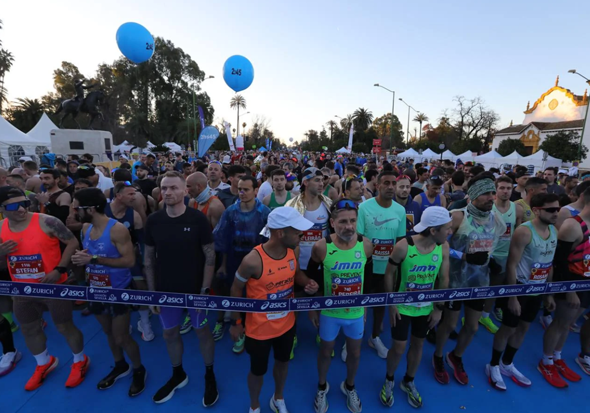 Corredores del Zurich Maratón de Sevilla 2025 preparados en la línea de salida, en el Paseo de las Delicias