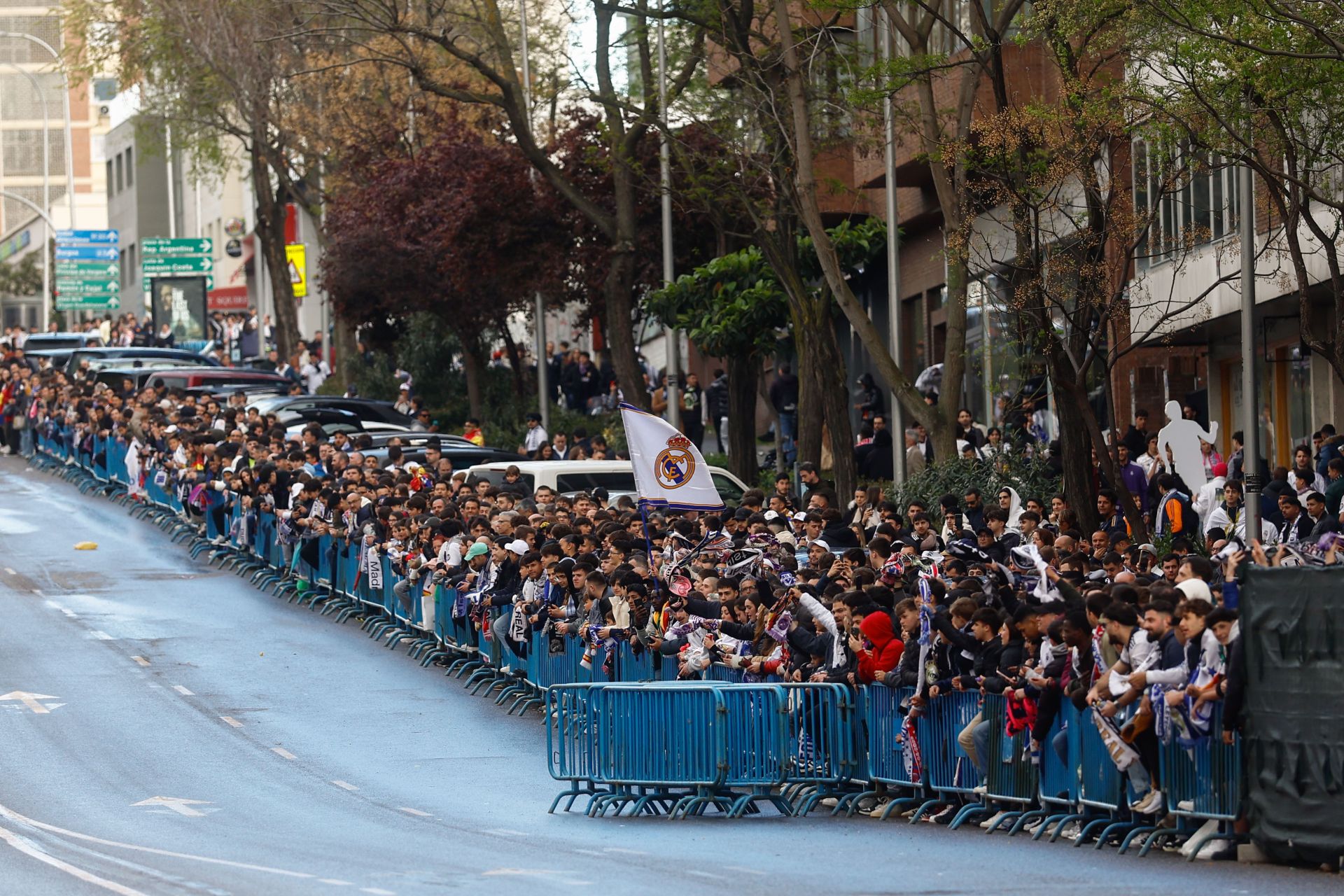 Aficionados del Real Madrid esperan el autobús del equipo en el Santiago Bernabéu.