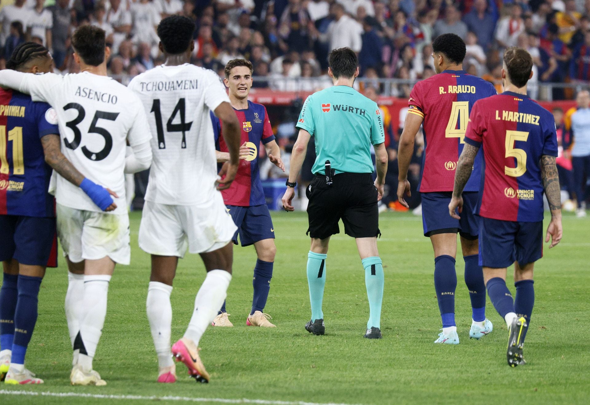 Momento en el que el árbitro rectifica un penalti pitado anteriormente de Asencio sobre Rapinha (abrazados en la imagen).