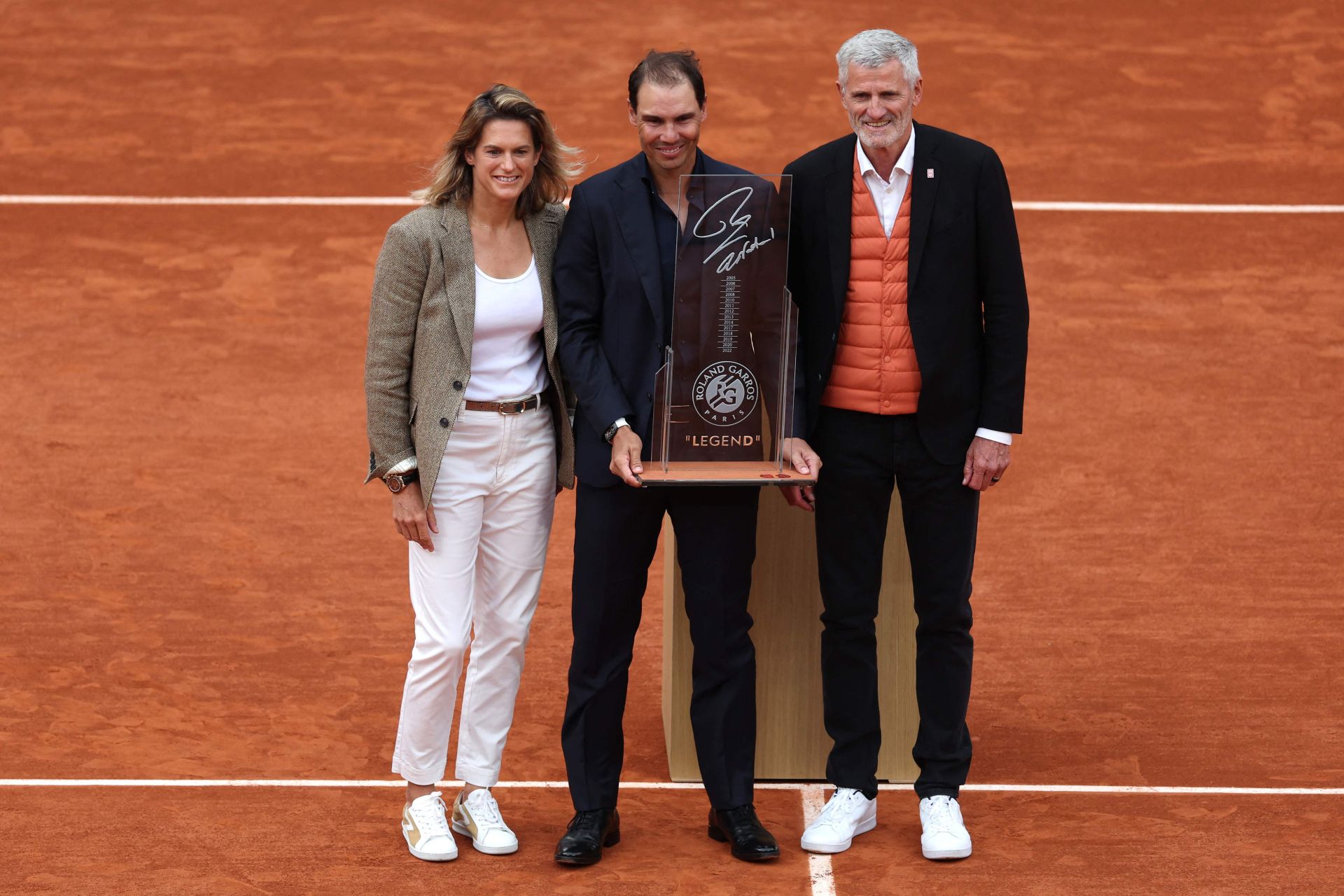 Nadal posa con una placa conmemorativa que le han regalado desde la organización de Roland Garros. Junto a Amelie Mauresmo, directora del torneo, y Gilles Moretton, presidente de FFT. 