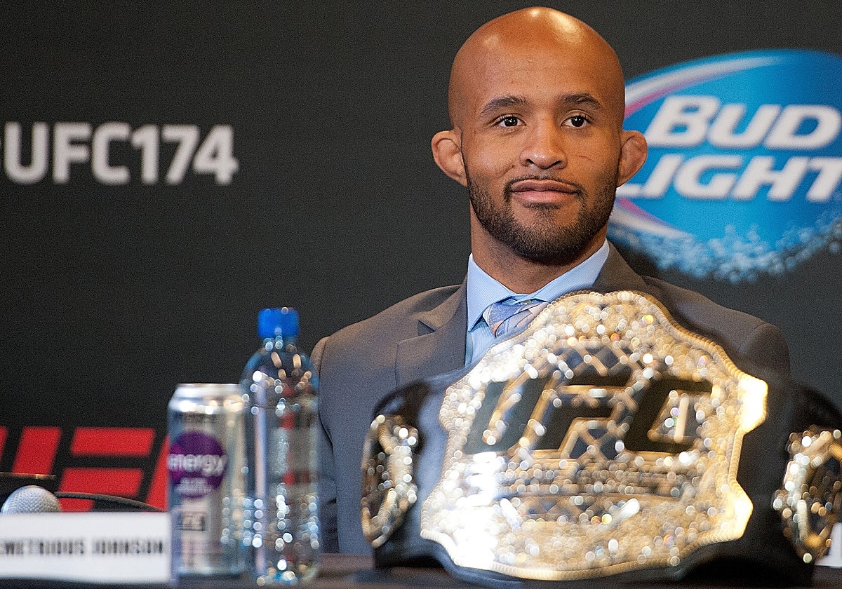 Demetrious Johnson con su cinturón de campeón en una rueda de prensa