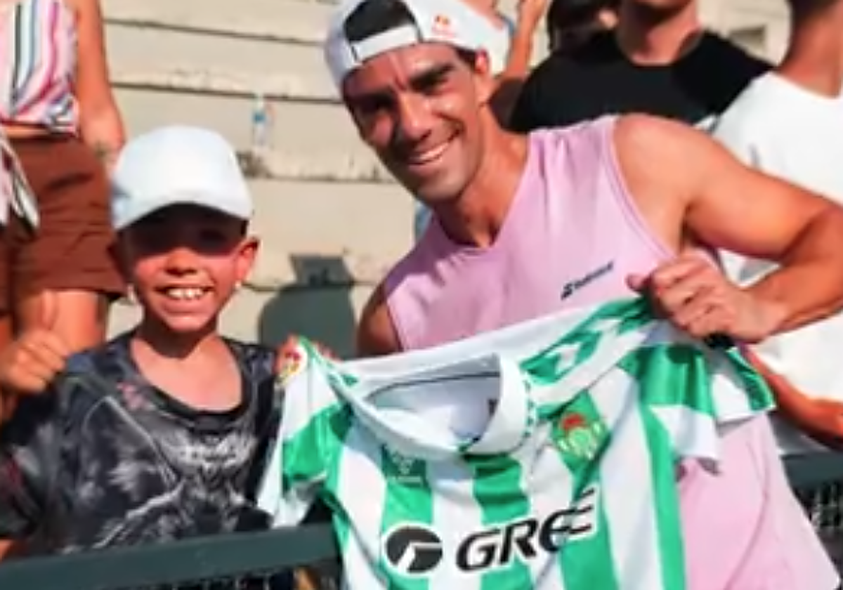 Juan Lebrón, juanto al aficionado que le regaló la camiseta del Real Betis