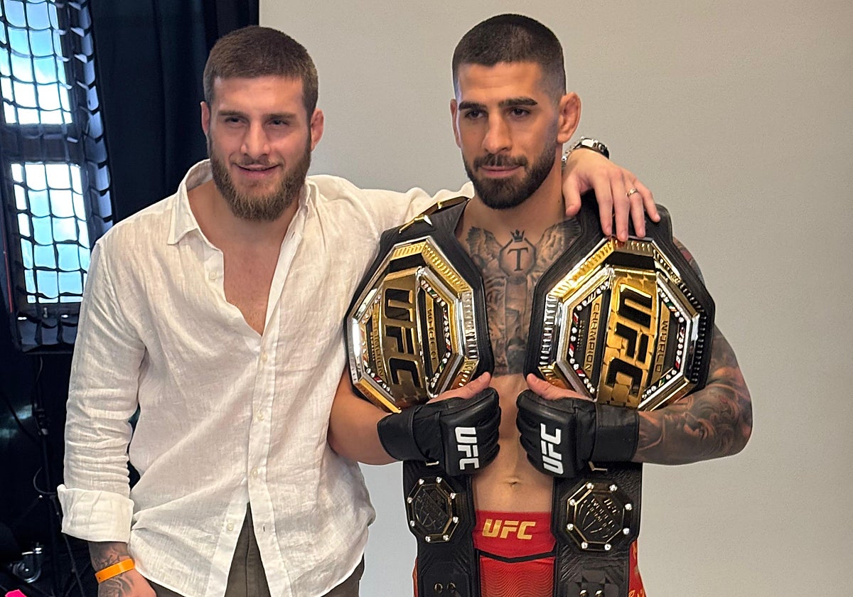 Ilia Topuria posa con dos cinturones de la UFC, junto a su hermano Aleksandre