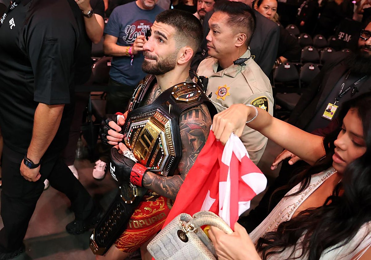 Ilia Topuria sale del octágono con los dos cinturones de la UFC